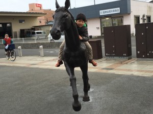 野馬に乗って広場を駈ける少年（⁉）